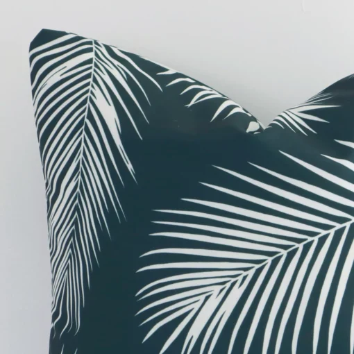 Close up of an outdoor square cushion in green. The quality of its palm design is shown in fine detail.