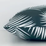 A square cushion positioned flat to show its seams. The green colour and palm design are visible as is the seam between the panels.