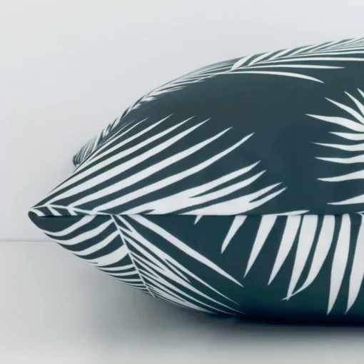 A square cushion positioned flat to show its seams. The green colour and palm design are visible as is the seam between the panels.
