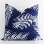A bold palm motif outdoor cushion in a sleek square size with a navy tone of colour.