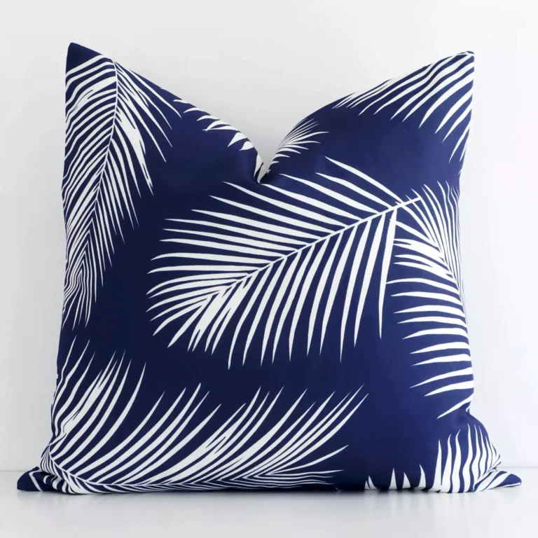 A bold palm motif outdoor cushion in a sleek square size with a navy tone of colour.