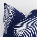 Close up image of top corner of this palm printed navy cushion. This shows the outdoor fabric and square shape up close.