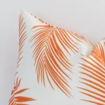 This image shows an orange palm printed cushion cover from a very close range. The rectangle size and outdoor material are more clearly shown.