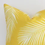 A zoomed in photo of the corner of a yellow outdoor cushion that has outdoor fabric and a square size.