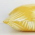 Yellow palm styled cushion in yellow colour laying flat. The viewpoint highlights the seams of the outdoor fabric.