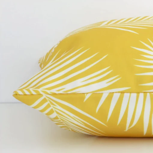 Yellow palm styled cushion in yellow colour laying flat. The viewpoint highlights the seams of the outdoor fabric.