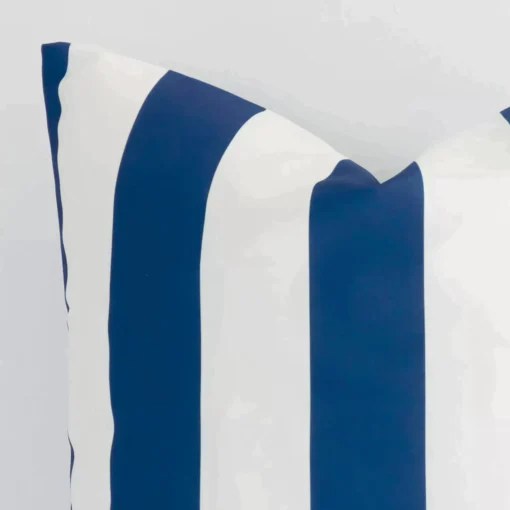 The corner of this outdoor large cushion cover is shown close up. The striped design and navy colour are shown in greater detail.