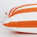 Side edge of orange striped large cushion. The outdoor material can be seen from this lateral viewpoint.