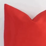Zoomed in visual of outdoor square cushion cover in red. The beauty of its solid colour design is visible.