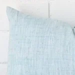Horizontal edge view of front and back panels of a linen cushion in a rectangle size and with duck egg colouring.