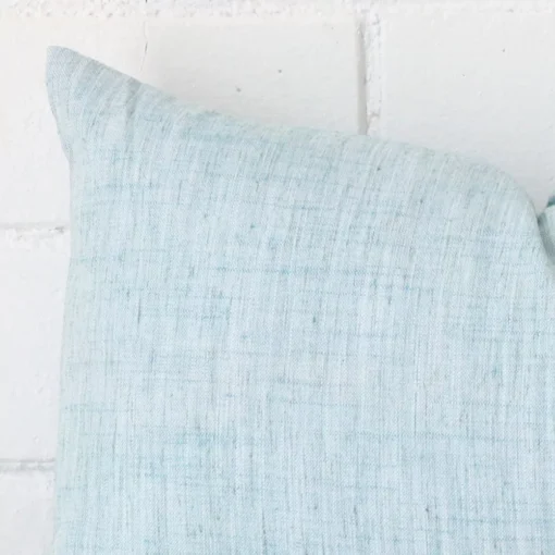 Horizontal edge view of front and back panels of a linen cushion in a rectangle size and with duck egg colouring.