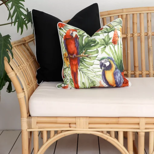 A rattan outdoor seat adorned with black cushion covers carefully arranged on its corner inviting you to unwind in style.