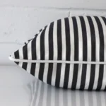 Square cushion in black and white colour laying flat. The viewpoint highlights the seams of the outdoor fabric.