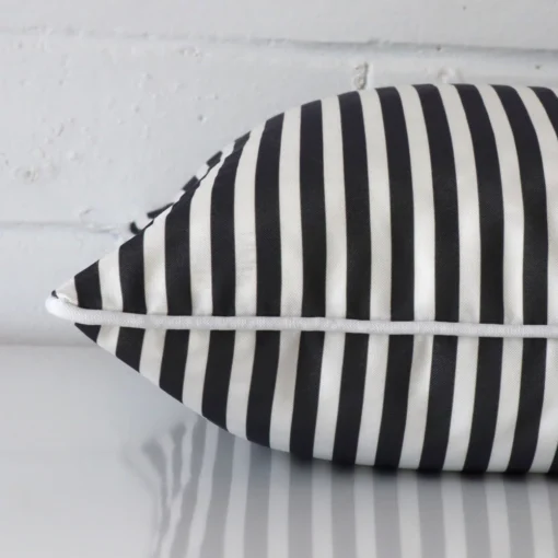 Square cushion in black and white colour laying flat. The viewpoint highlights the seams of the outdoor fabric.