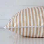Enlarged image of the side of this outdoor cushion. The angle highlights how the square design and striped decorative finish are joined along the seam.