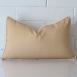 A brick wall that has a beige cushion cover positioned in front of it. It has an exquisite outdoor material and a lovely rectangle shape.
