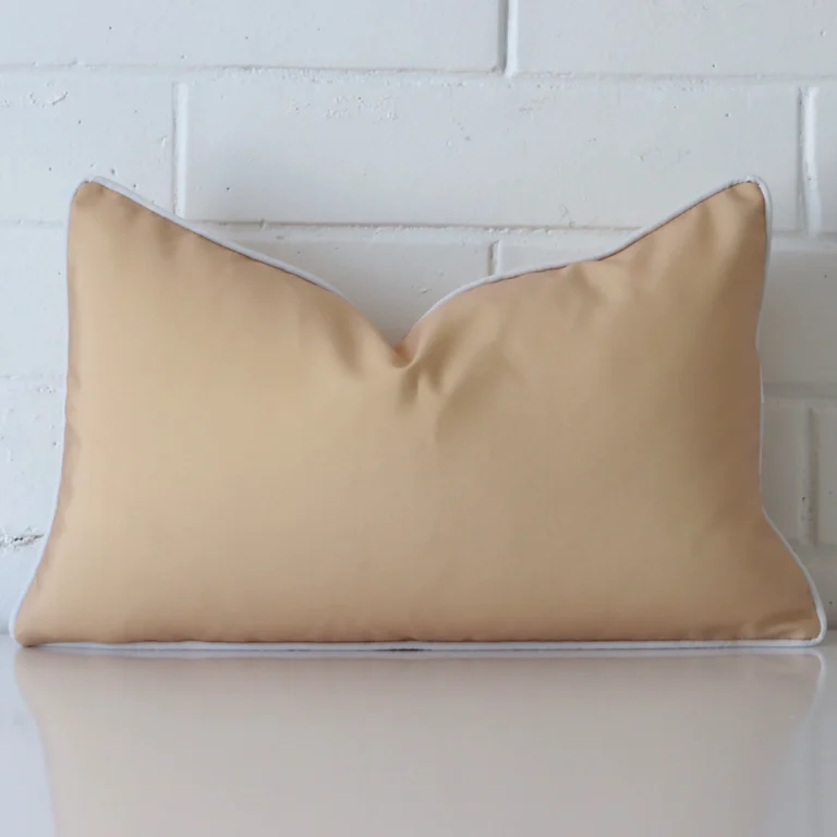 A brick wall that has a beige cushion cover positioned in front of it. It has an exquisite outdoor material and a lovely rectangle shape.