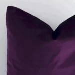 Close up view showing a corner of this solid-coloured velvet cushion in a square size and with velvet colouring.