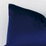 A detailed shot of this royal blue solid-coloured cushion cover that has velvet fabric and a rectangular shape.