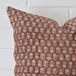 Extreme close up of a large cushion. The floral style and designer fabric are shown with a much higher degree of detail.