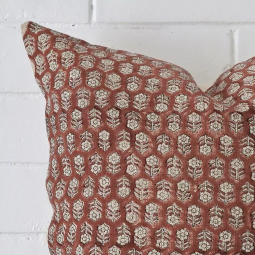 Extreme close up of a large cushion. The floral style and designer fabric are shown with a much higher degree of detail.