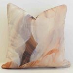 Sienna outdoor cushion with abstract brushstroke pattern in soft peach and brown tones.