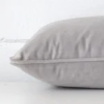 Side shot showing the seam of this rectangle silver grey cushion that features a velvet material.
