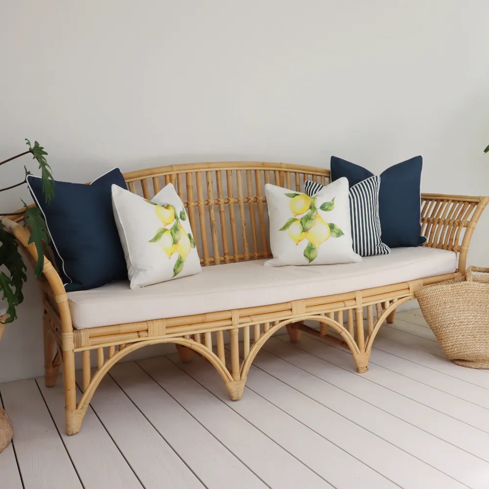 Styled outdoor lounge cushions on a seat outside.