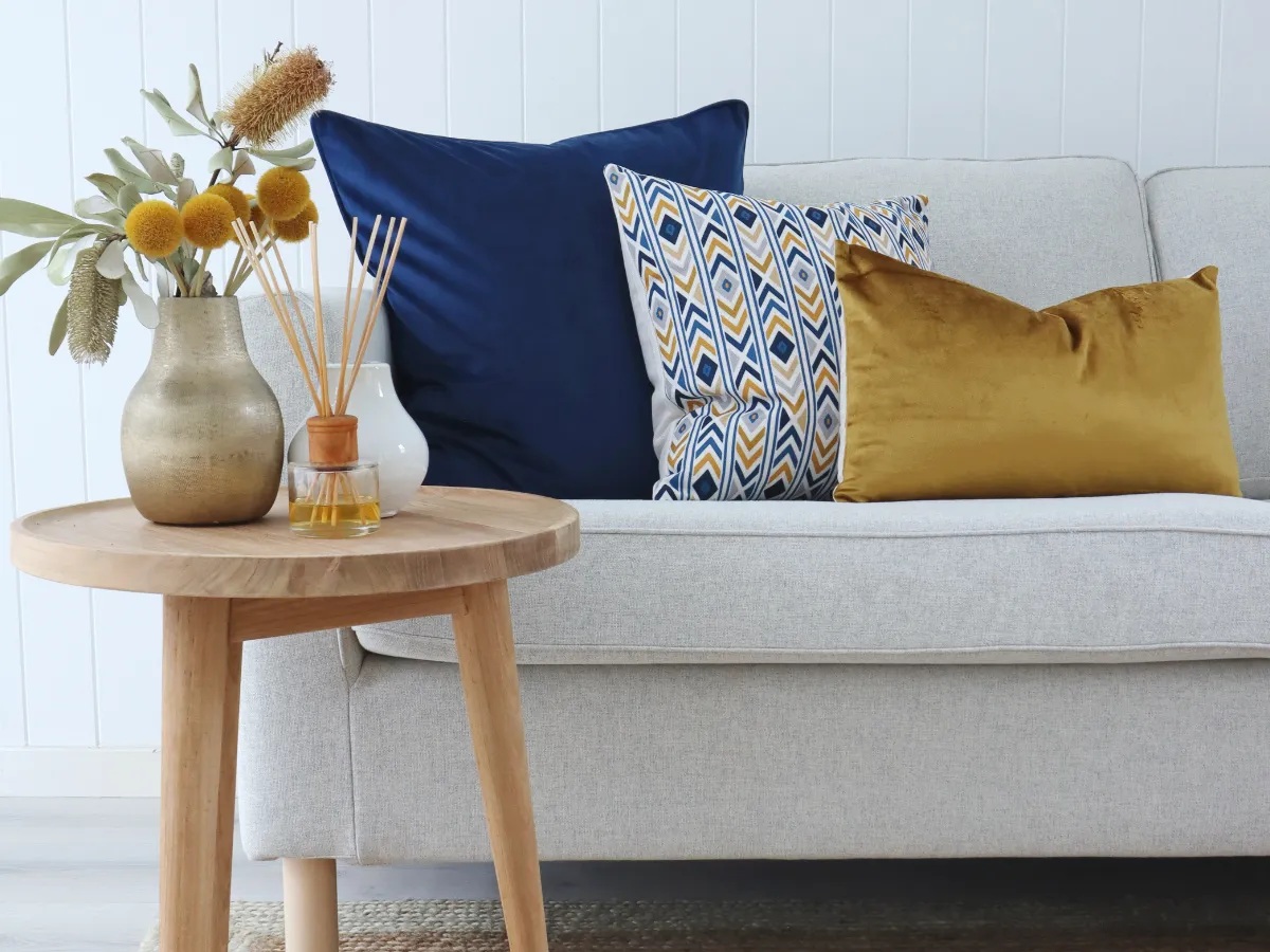 Three cushion designs on a couch with vibrant blue and yellow colours.