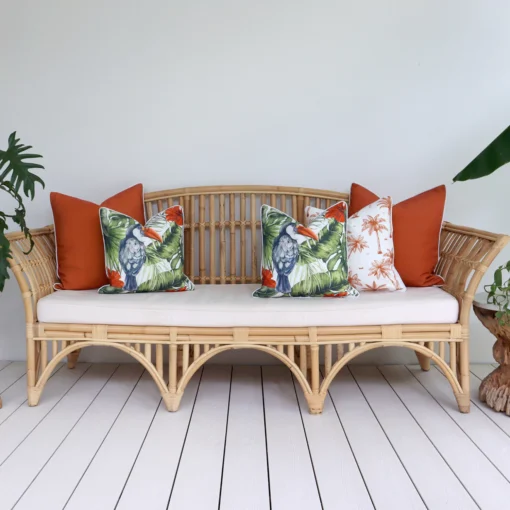 Five terracotta-coloured outdoor cushions adorn a rattan seat creating a flawless fusion.