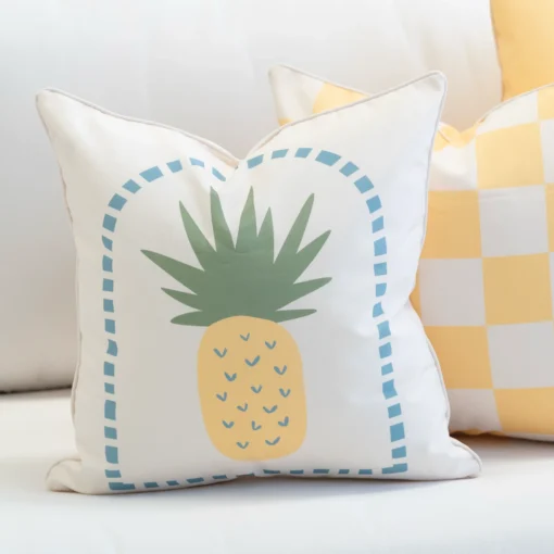 Tropica cushion with yellow pineapple design and blue dotted border.