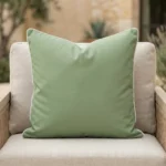 Tropica green cushion with white piping on outdoor armchair seat.