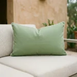 Tropica green rectangular cushion with white trim on outdoor sofa.
