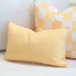 Tropica lemon yellow rectangular cushion with check cushion behind on sofa.