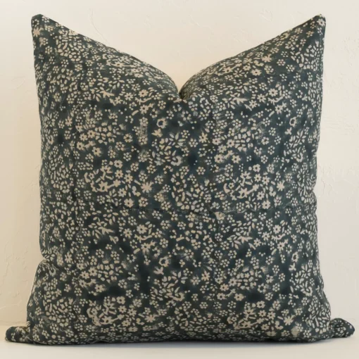 vada-floral-designer-cushion-cover---art129 Dark moss green linen cushion cover features prominently against a white wall. It is a large design and has a floral decorative finish.