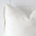 A zoomed view of this linen white cushion’s corner that shows a magnified view of its its large size.